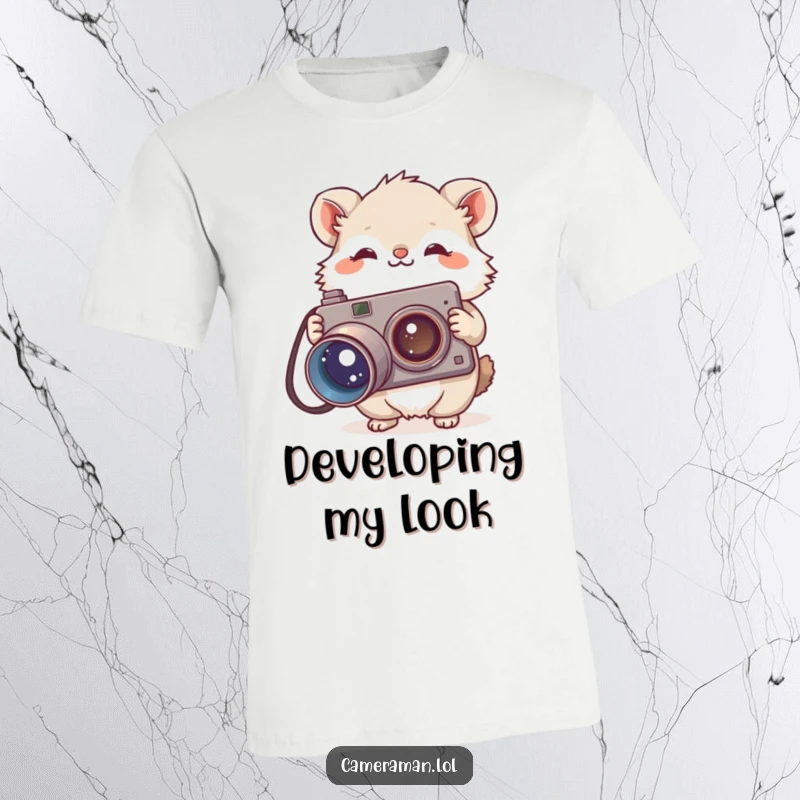 Funny t-shirt featuring a small, fluffy animal holding a large, vintage camera with a curious head tilt, ready to capture a moment.